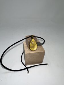 A wooden block with a necklace on it