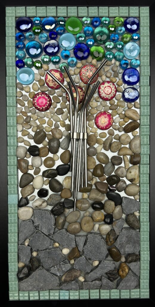 A mosaic of rocks and flowers with a metal pole.